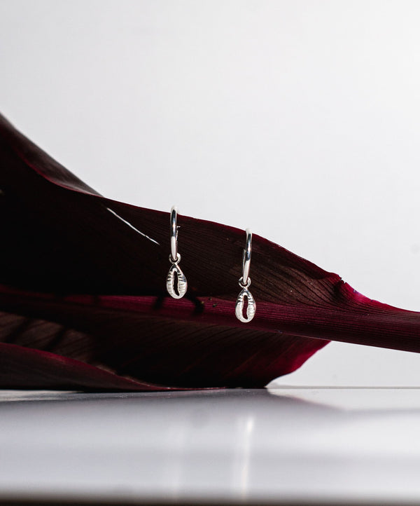Boucles pendantes en argent sur une feuille sombre