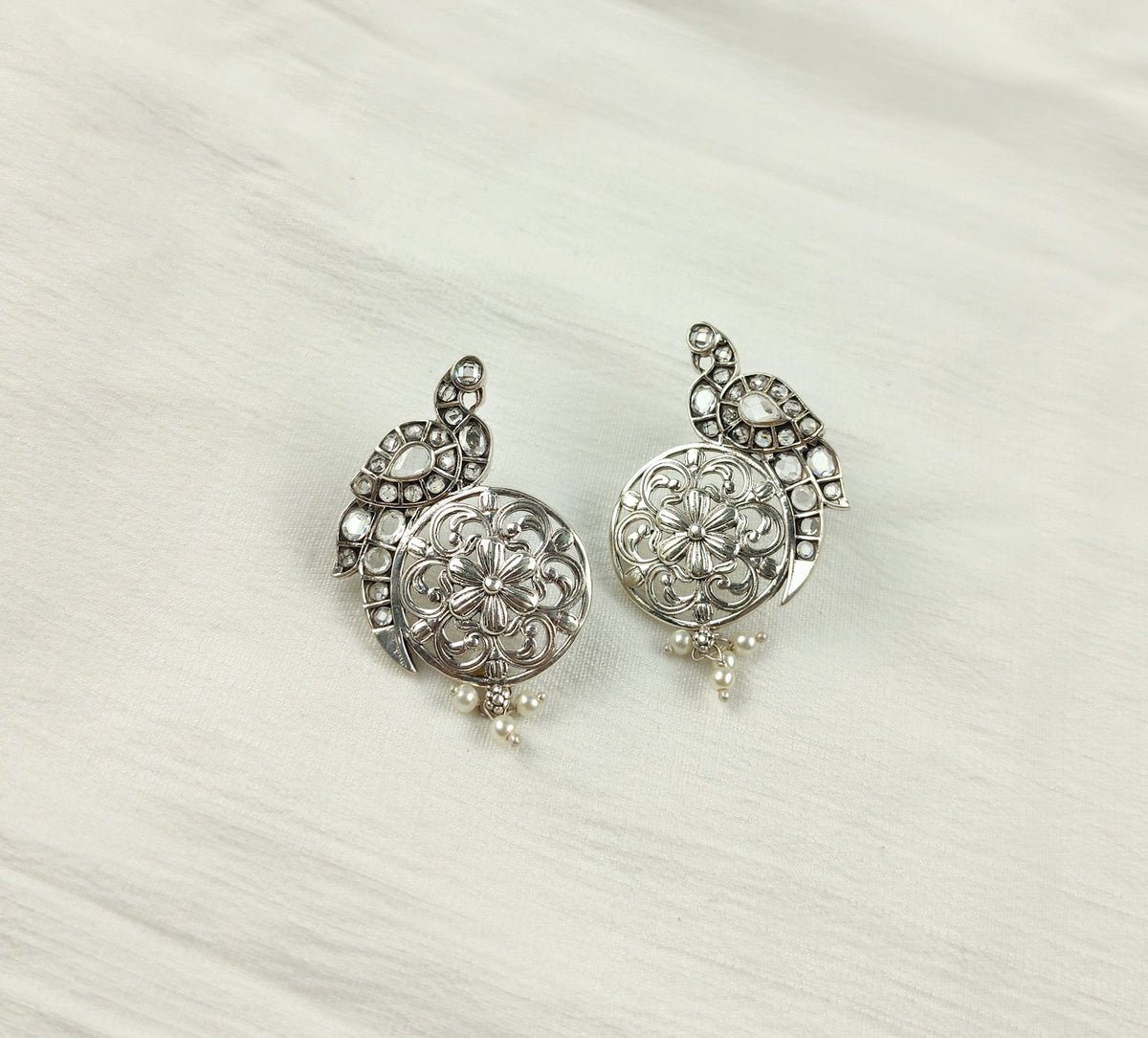 Boucles d'oreilles filigrane en argent sur tissu blanc