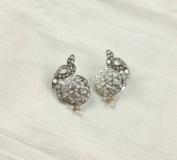 Boucles d'oreilles filigrane en argent sur tissu blanc